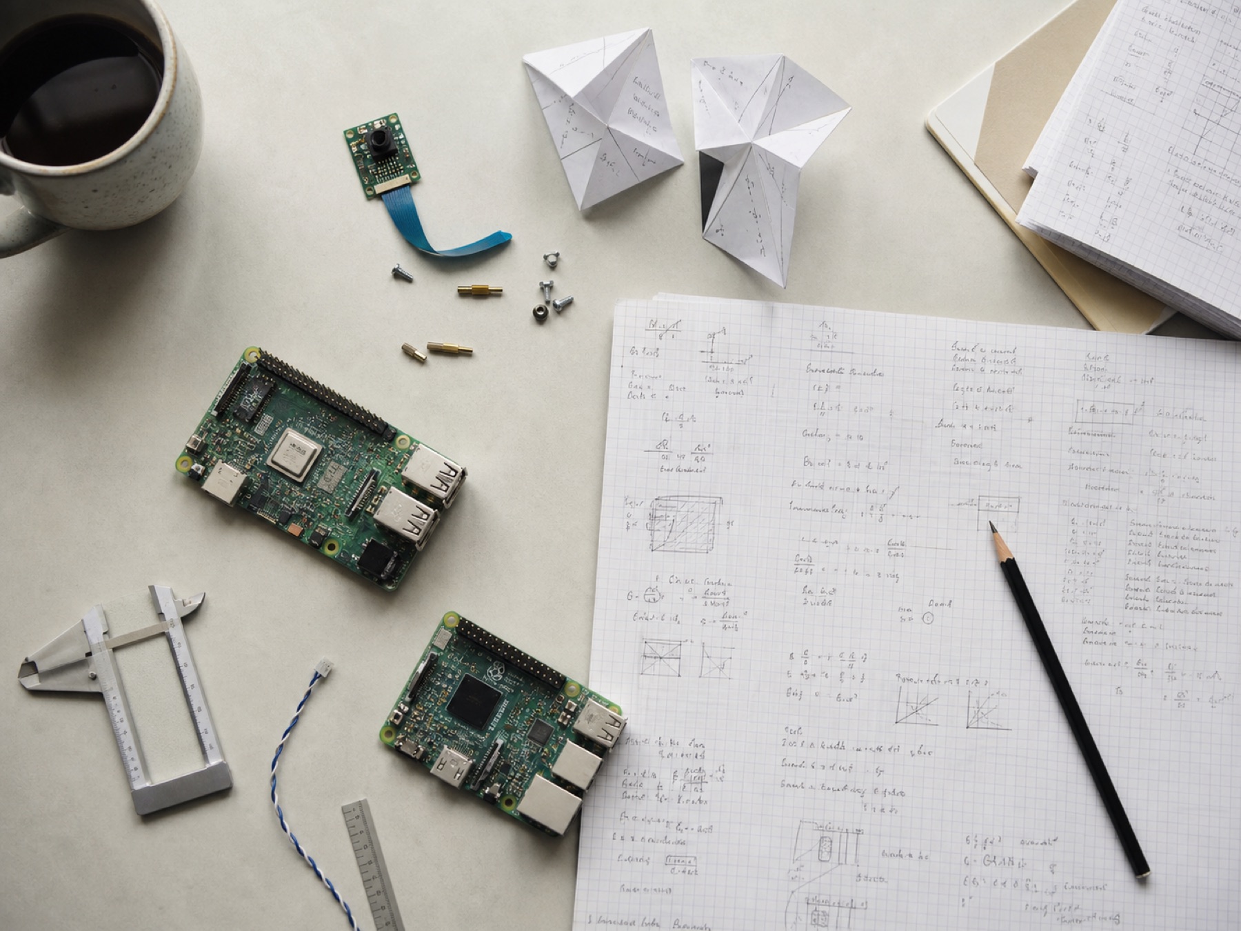 Applied AI hardware, technical notes, and prototypes arranged on a workbench